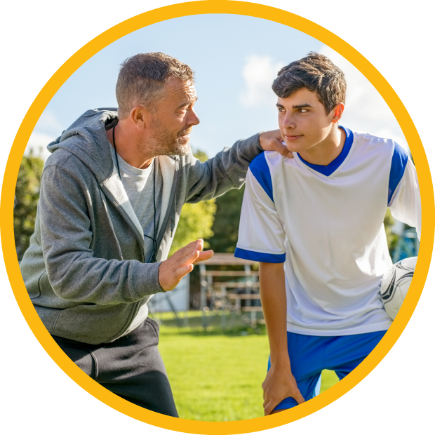 Teacher speaking with student holding football